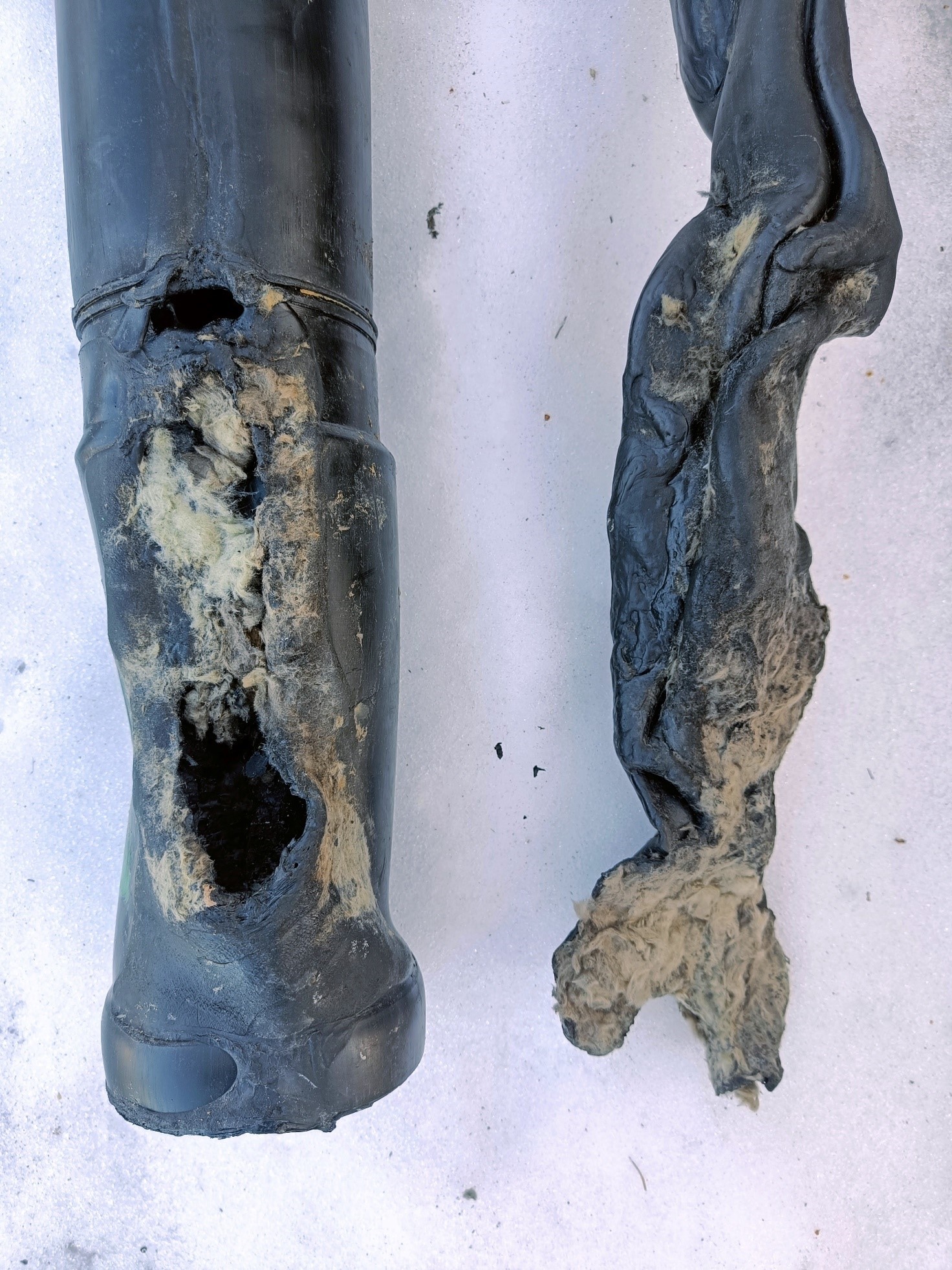 A melted black plastic sewer pipe.